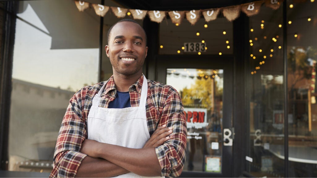 Photo of successful person in front of business after working in Catholic Charities Workforce Development program